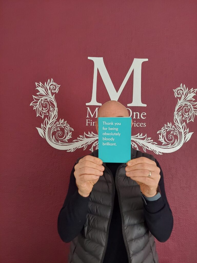 Mark Covers Face with Thank You Card
