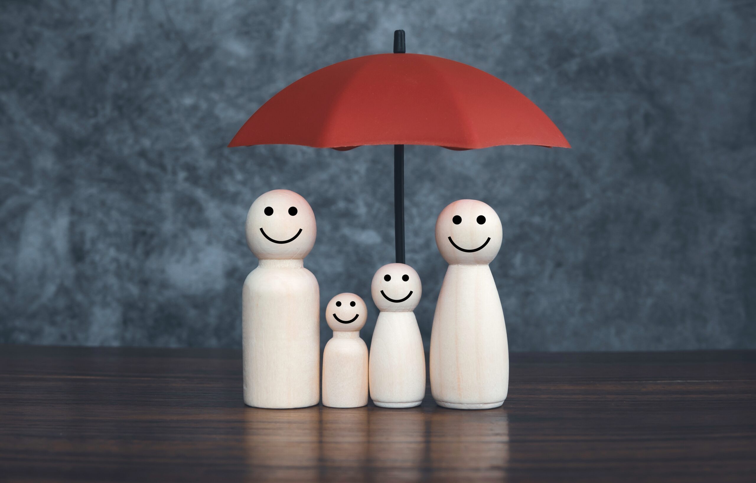 Family figurines under an umbrella referencing income protection