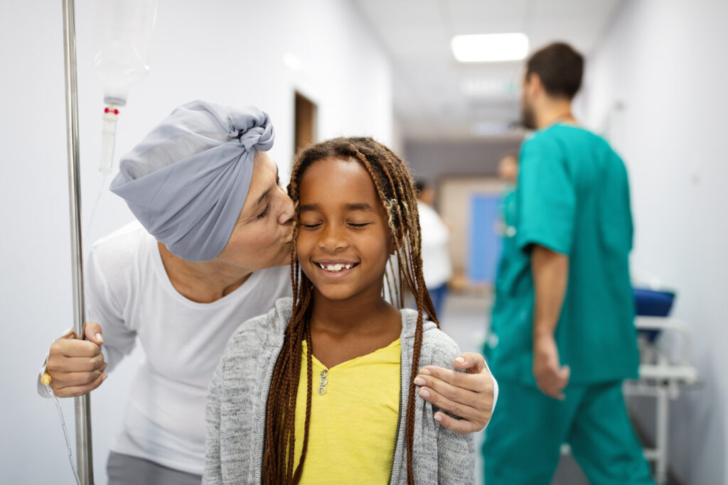 Sick woman with cancer hugging her young grandchild in hospital.
